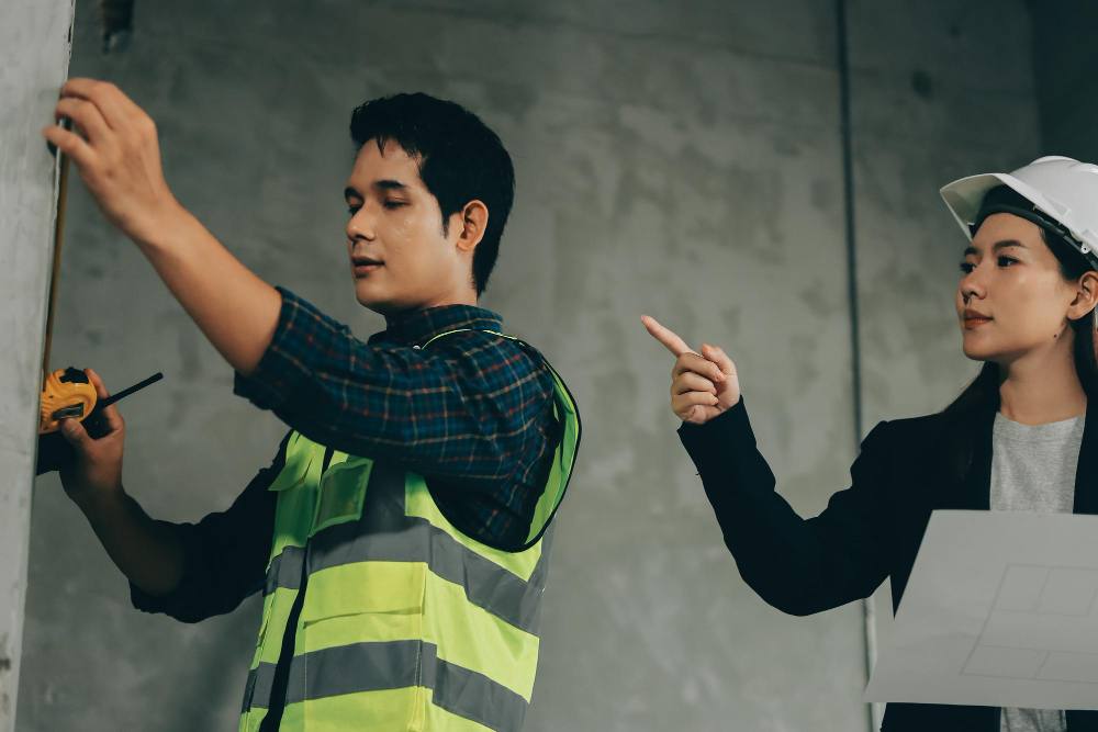 A female supervisor is instructing a renovation worker.